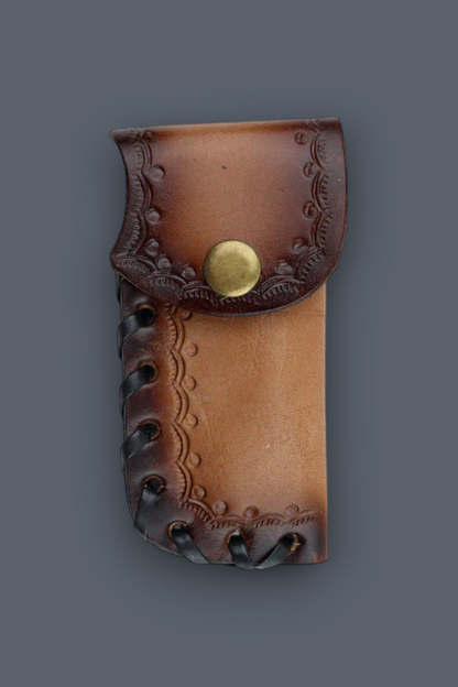 A brown leather pouch with embossed floral detailing, a snap button closure, and decorative stitching along the edges, shown against a solid dark gray background.