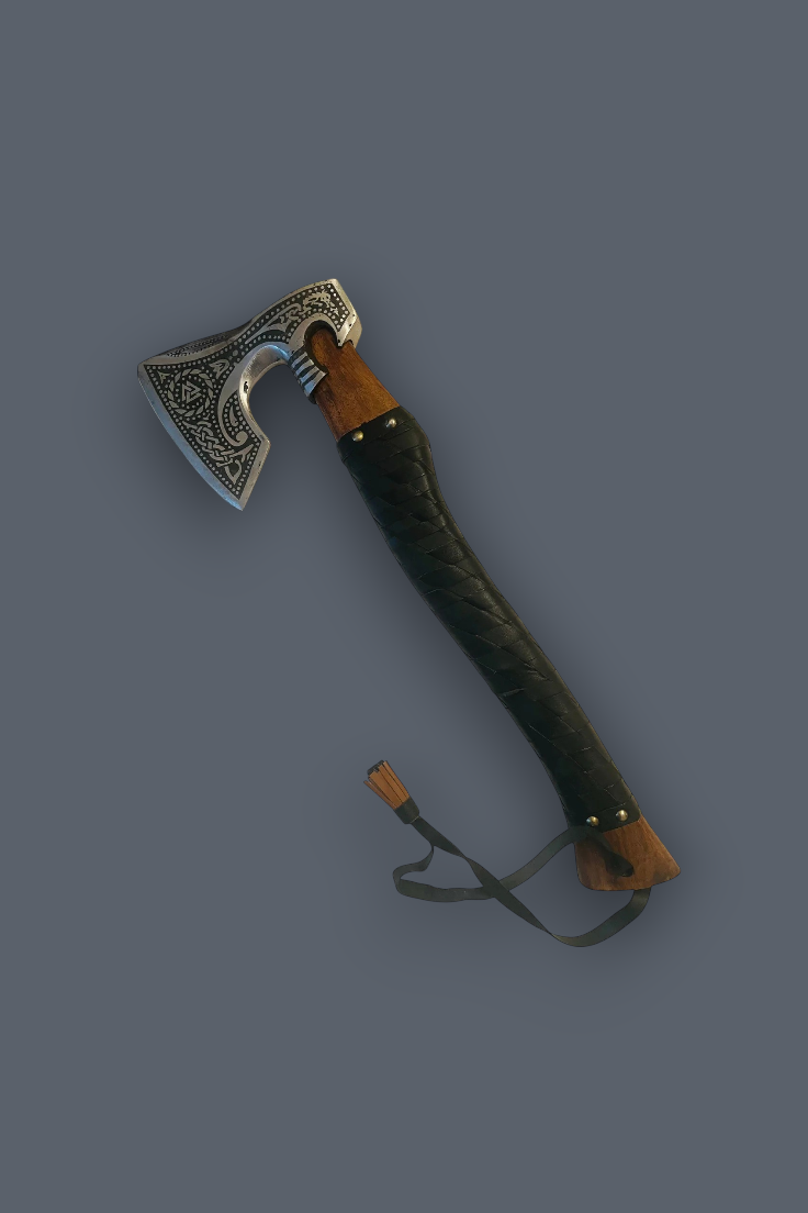A decorative Viking-style axe with an engraved silver blade, brown wooden handle sections, and a dark textured grip, shown on a solid dark gray background.