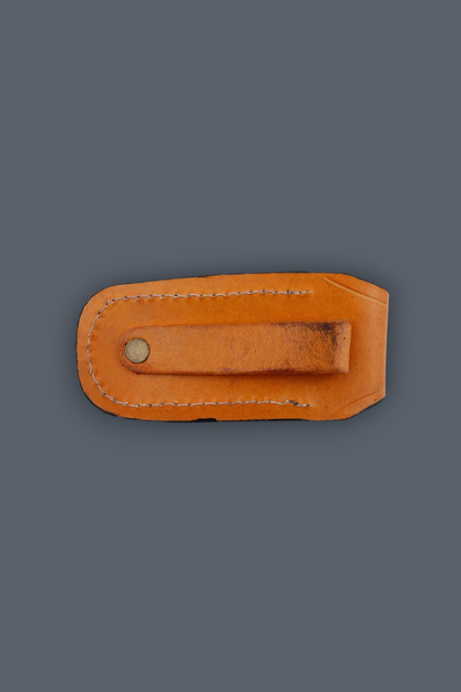 A light brown leather money clip with a metal snap button, shown flat against a solid dark gray background.