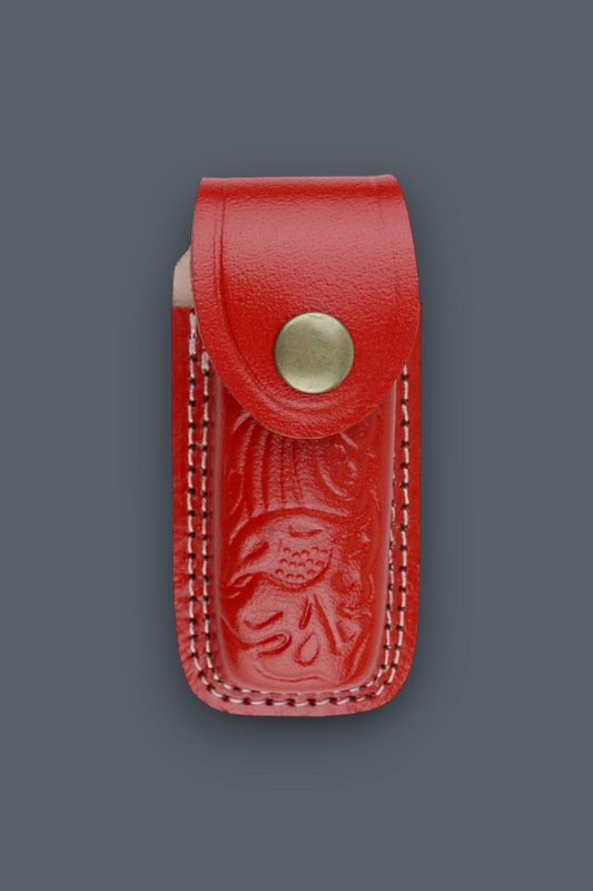 A red leather knife sheath with an embossed floral design and a brass snap button, shown against a solid dark gray background.