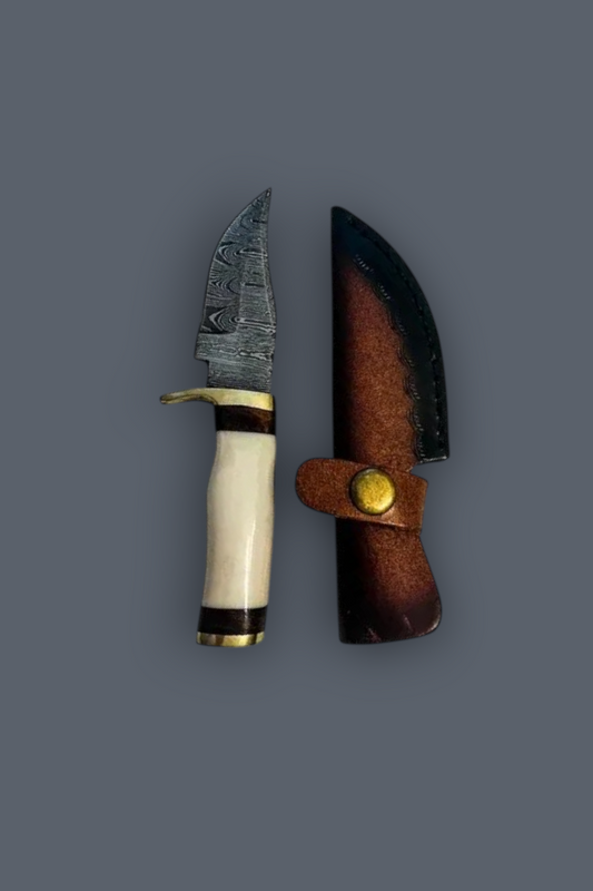 A fixed-blade knife with a patterned steel blade, cream-colored handle, and dark brown leather sheath, displayed against a solid dark gray background.