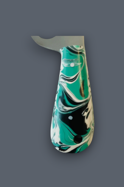 A kitchen knife with a curved silver blade and a marbled resin handle in teal, white, and black, shown against a solid dark gray background.