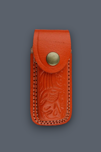 A small orange-red leather pouch with an embossed floral design, double-stitched edges, and a brass snap button, shown against a dark gray background.