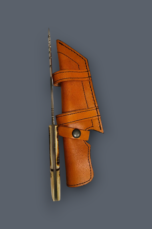 A folding pocket knife with a brass-colored handle and a sharp silver blade, shown partially sheathed in a brown leather sheath against a solid dark gray background.