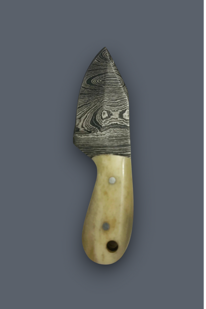 A small knife with a patterned Damascus steel blade and a light beige bone handle, shown vertically against a solid dark gray background.