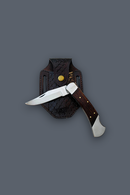 A folding pocket knife with a silver blade and dark brown wooden handle, shown partially sheathed in a dark brown leather sheath with brass rivets, set against a solid dark gray background.