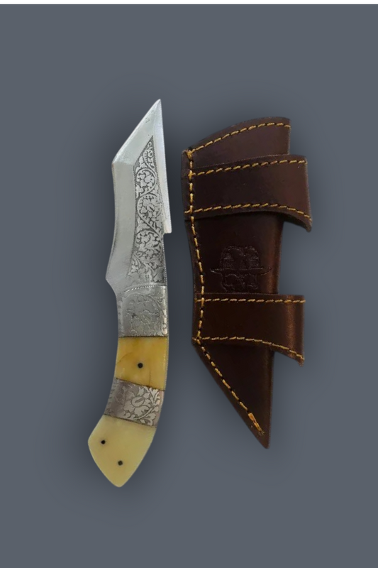 A fixed-blade knife with a patterned steel blade, a silver bolster, and a yellow bone handle, shown next to its dark brown leather sheath on a solid gray background.