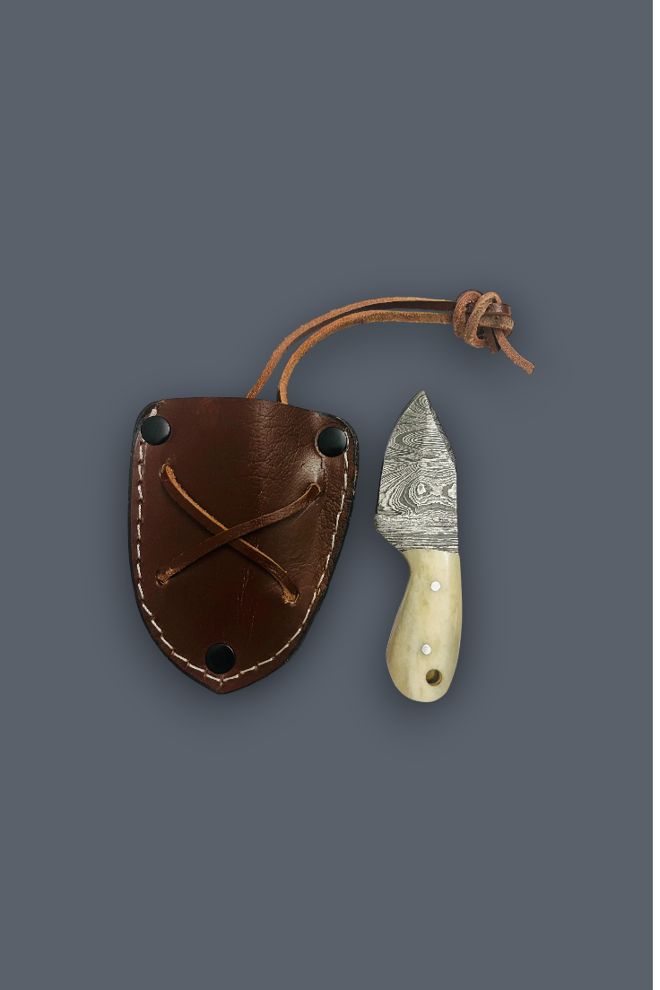 A small fixed-blade knife with a patterned steel blade and cream handle, shown next to its brown leather sheath on a solid dark gray background.