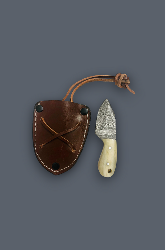 A small fixed-blade knife with a patterned steel blade and cream handle, shown next to its brown leather sheath on a solid dark gray background.