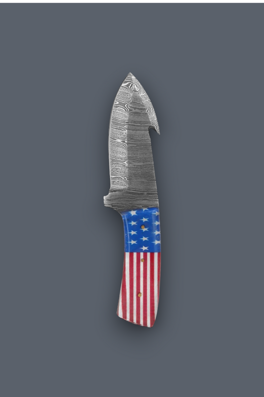 A fixed-blade knife with a patterned steel blade and a handle featuring an American flag design, shown against a solid dark gray background.