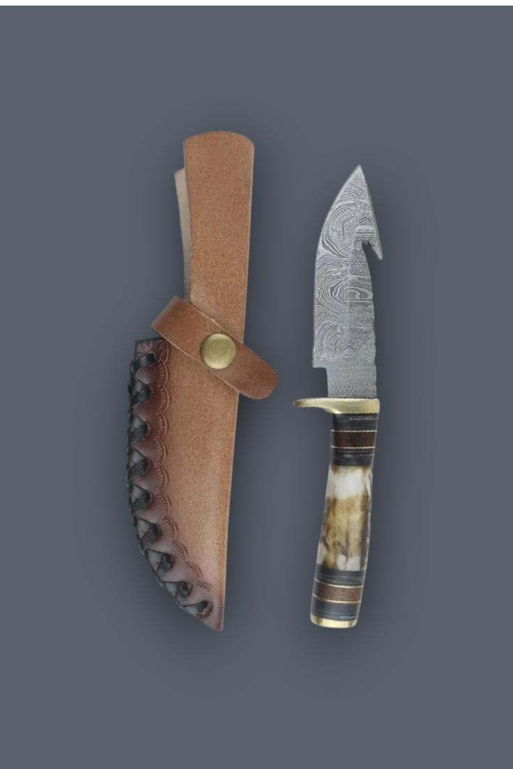 A fixed-blade knife with a patterned steel blade, a horn-like handle, and a brass guard, shown next to its brown leather sheath on a dark gray background.