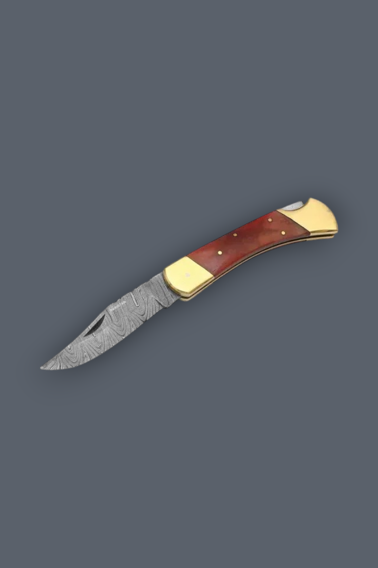 A folding pocket knife with a Damascus steel blade, featuring a reddish-brown wood handle with brass bolsters, shown on a solid dark gray background.