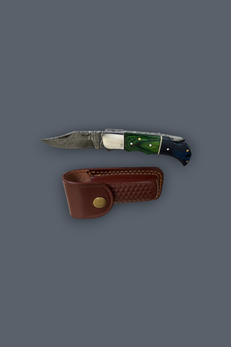 A folding pocket knife with a patterned steel blade, green and blue handle scales, and a brown leather sheath, displayed on a solid dark gray background.