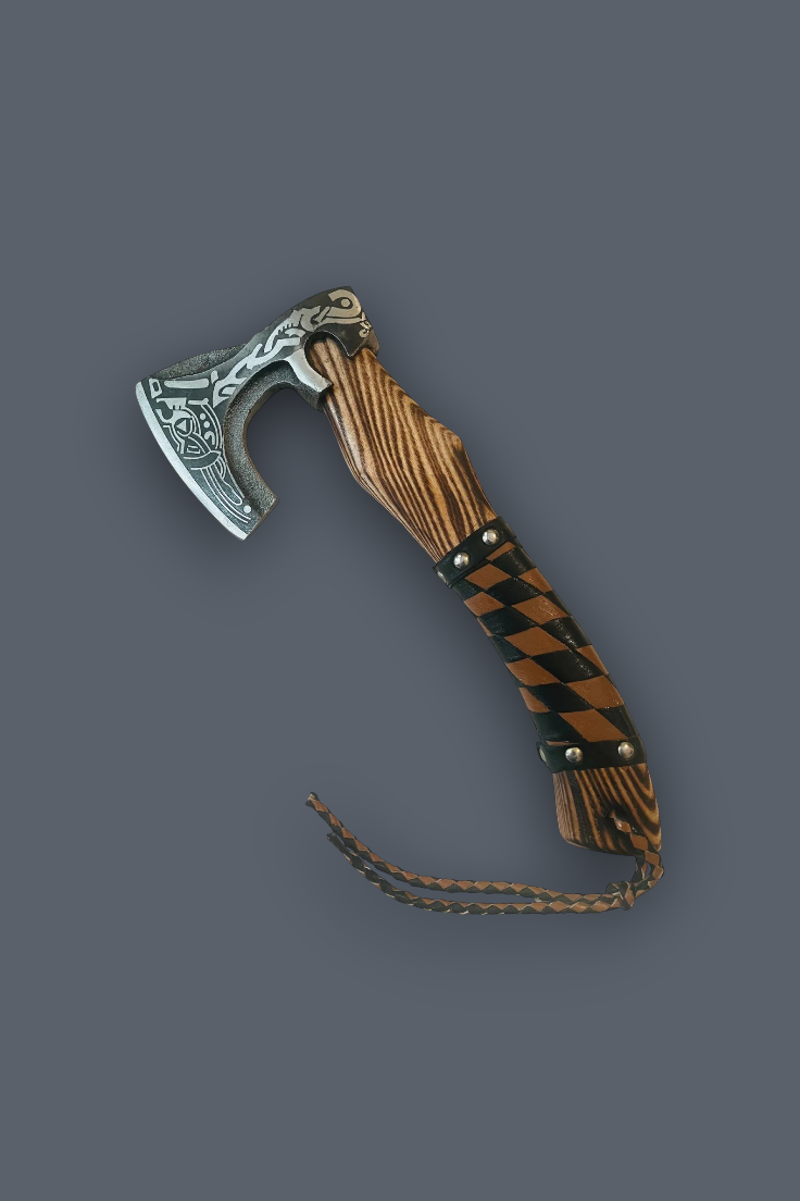 A decorative Viking-style axe with an ornate silver-toned metal head, a brown and black checkered wooden handle, and a braided leather lanyard, shown on a solid dark gray background.