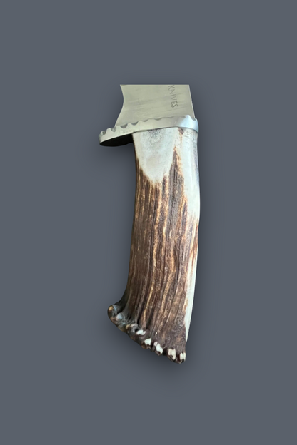 A handcrafted knife with a natural antler handle and a silver metal blade, shown against a solid dark gray background.