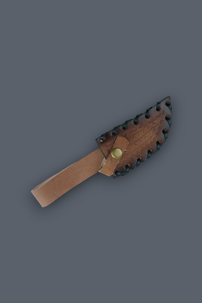 A small knife with a tan leather handle and a dark brown leather sheath featuring serrated edges and a brass snap, shown on a solid dark gray background.