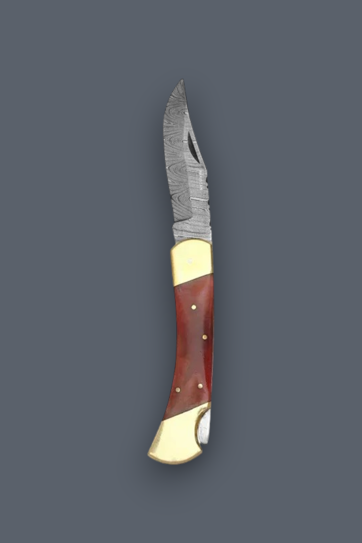 A folding pocket knife with a patterned steel blade, a reddish-brown wooden handle, and polished brass bolsters, shown against a solid dark gray background.