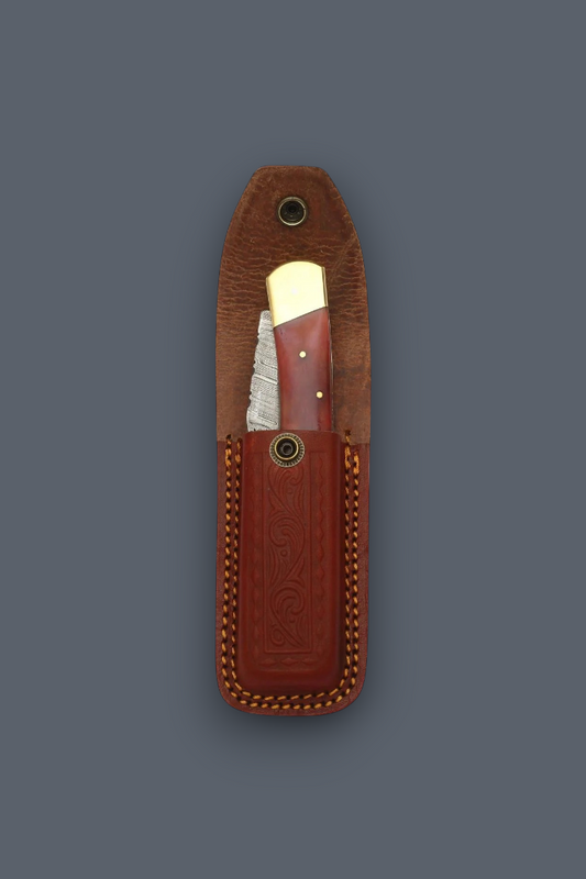 A folding pocket knife with a reddish-brown handle and silver blade, partially pulled from a brown leather sheath on a dark gray background.