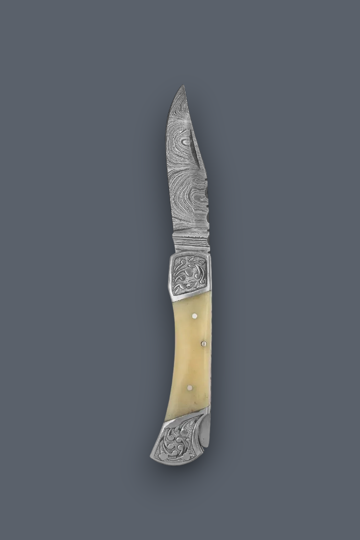 A folding pocket knife with a patterned steel blade, ornate silver-toned metal fittings, and a curved cream-colored bone handle, shown against a solid dark gray background.