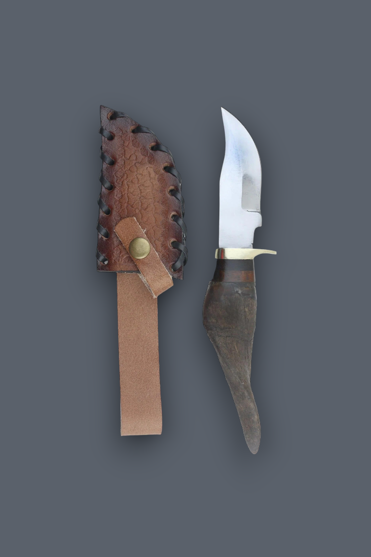 A fixed-blade knife with a curved silver blade, dark textured handle, and brass guard, displayed next to its brown leather sheath on a solid dark gray background.