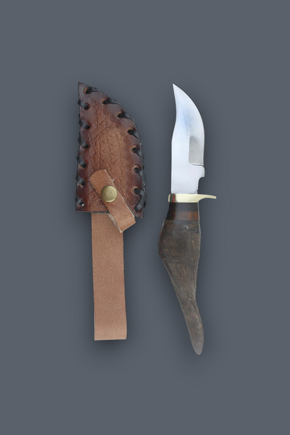 A fixed-blade knife with a curved silver blade, dark textured handle, and brass guard, displayed next to its brown leather sheath on a solid dark gray background.