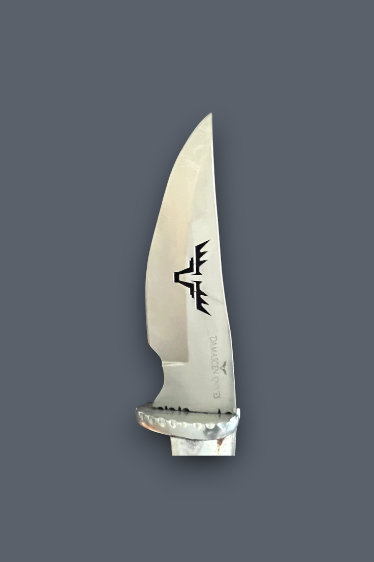 A custom steel knife with a polished silver blade featuring a black custom logo and the text 'Blunt Special', set against a solid dark gray background.