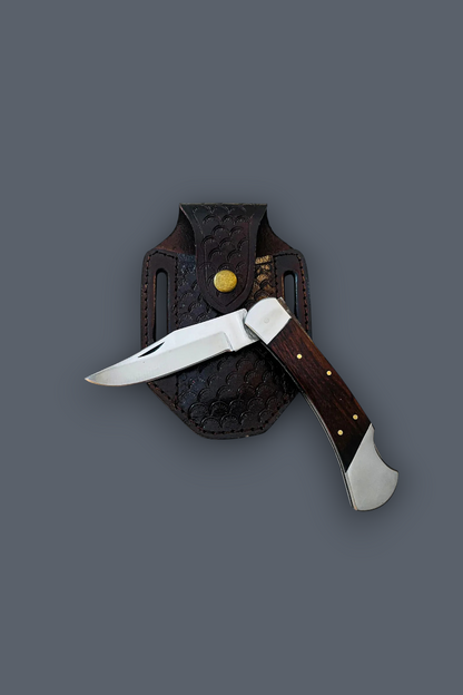 A folding pocket knife with a dark wood handle and silver blade, shown partially deployed next to its dark brown leather sheath on a solid dark gray background.