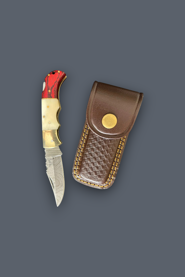 A folding pocket knife with a red and gold handle next to its brown leather sheath with gold-toned stitching, set against a solid dark gray background.