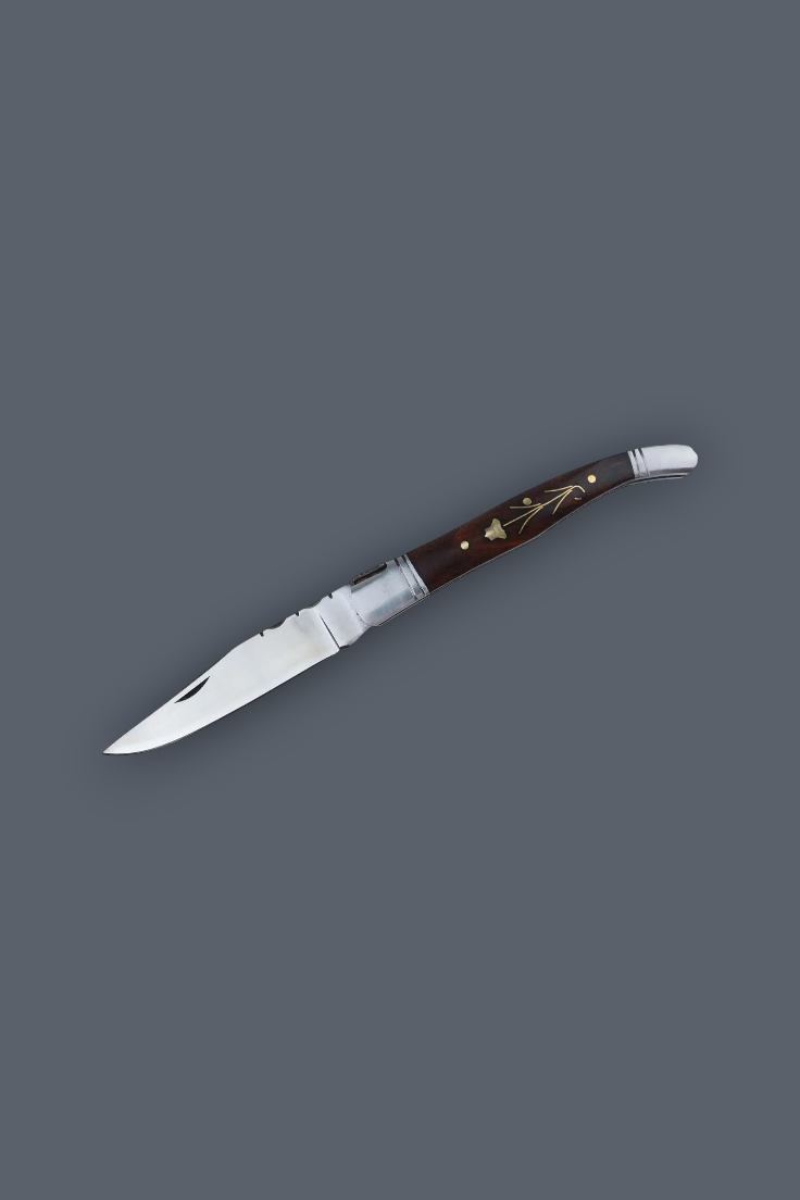 A folding pocket knife with a silver stainless steel blade and a dark brown wooden handle featuring gold floral inlay and silver metal accents, shown on a solid dark gray background.