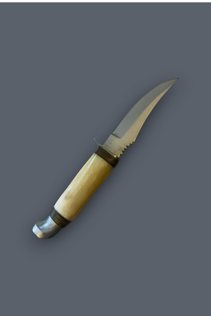 A curved fixed-blade knife with a light beige bone or horn handle, dark metal collar bands, and a silver steel blade, shown against a solid dark gray background.