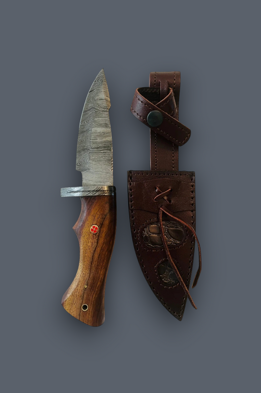 A fixed-blade knife with a patterned steel blade, a wooden handle, and a small red accent, shown next to its brown leather sheath on a dark gray background.