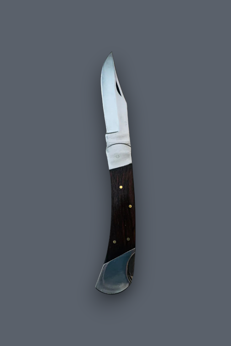 A folding pocket knife with a silver steel blade and a dark brown wooden handle accented with brass pins, shown against a solid dark gray background.