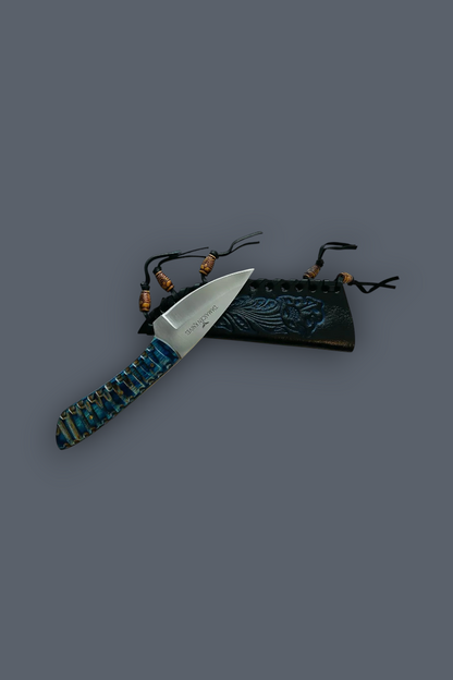 A fixed-blade knife with a silver blade and a textured handle wrapped in blue, green, and brown material, displayed next to a dark embossed sheath on a solid dark gray background.