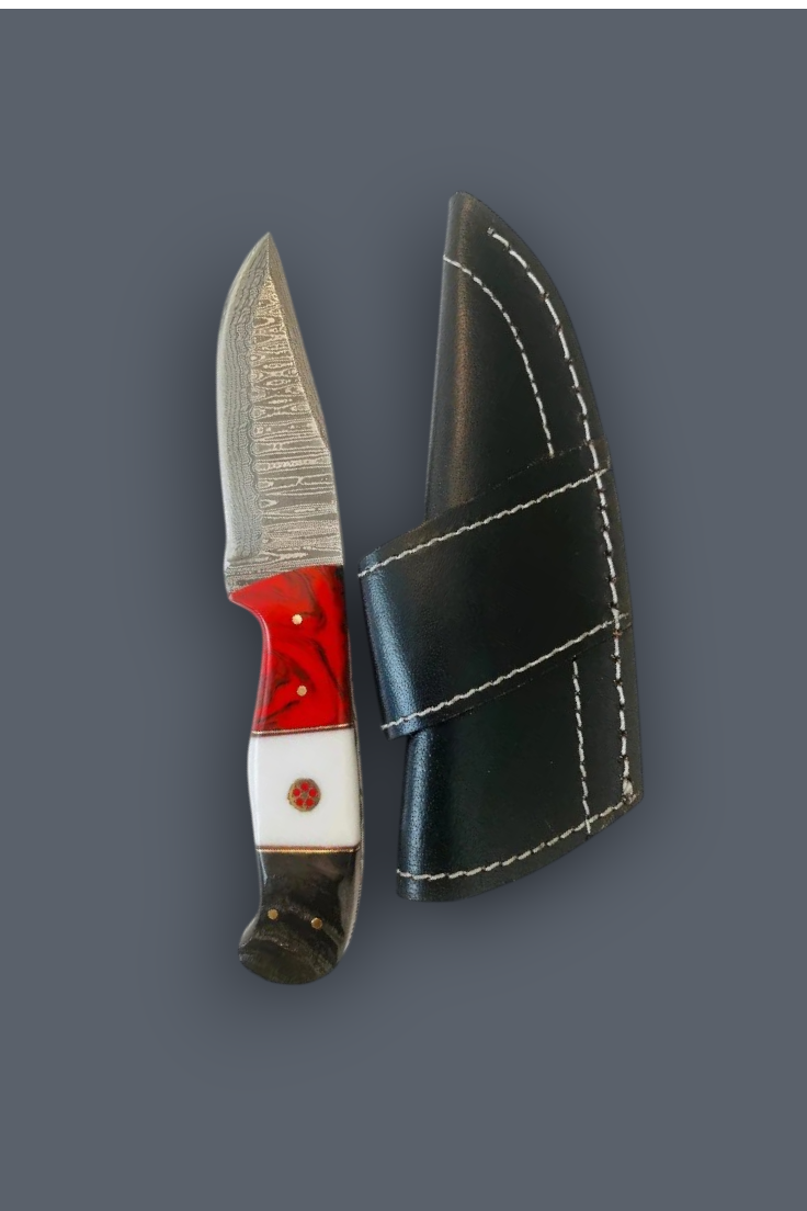 A fixed-blade knife with a textured silver blade, a red and white handle, and a black leather sheath with white stitching, displayed on a solid dark gray background.