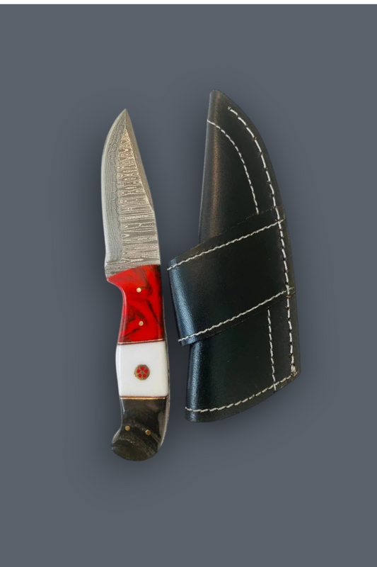 A fixed-blade knife with a textured silver blade, a red and white handle, and a black leather sheath with white stitching, displayed on a solid dark gray background.