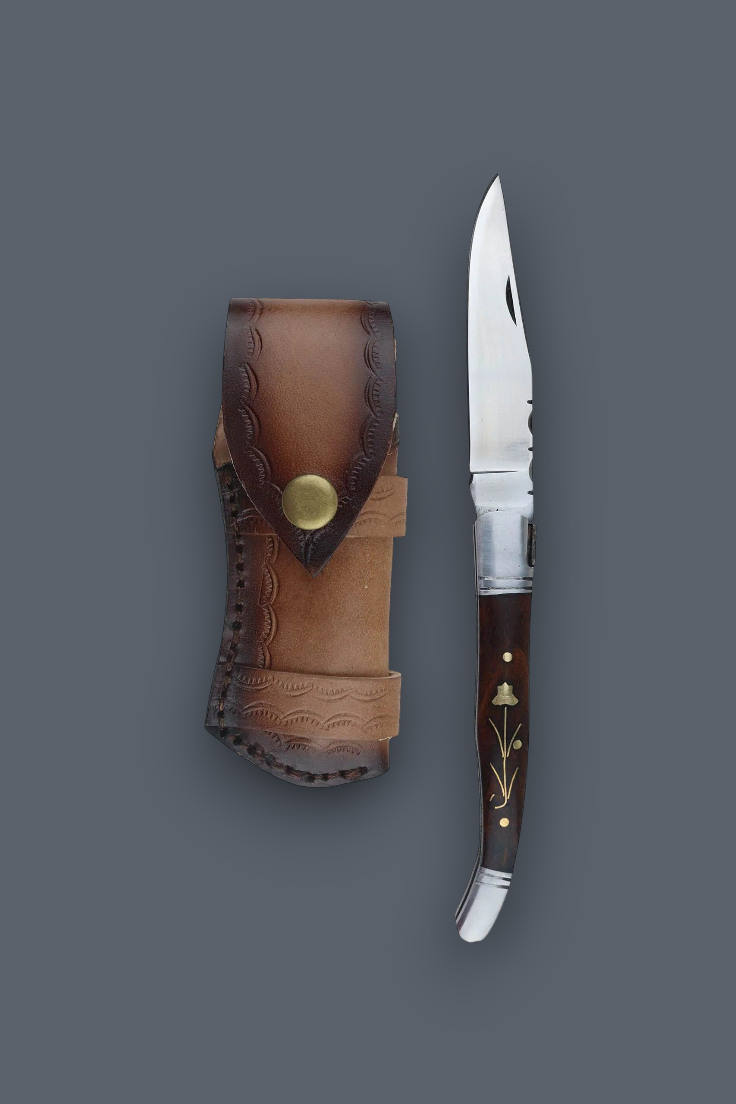 A folding pocket knife with a dark brown wooden handle and silver blade, displayed next to its brown leather sheath on a solid dark gray background.