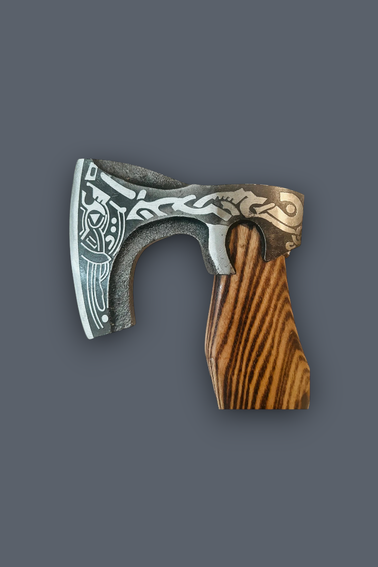 A decorative Viking-style axe with an engraved silver steel blade and a carved brown wooden handle, shown against a solid dark gray background.
