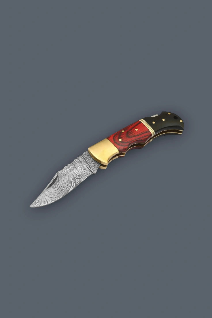 Angled overhead view of the fully open Pioneer Pocket Damascus folding knife featuring a classic lockback mechanism and multicolor wood handle.