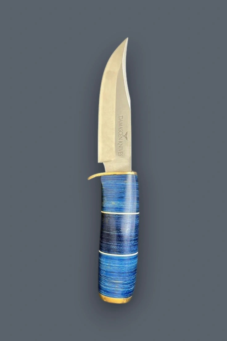 Diagonal view of the Blazefury Hunter stainless steel hunting knife, highlighting the blue wood handle and polished brass bolster assembly.