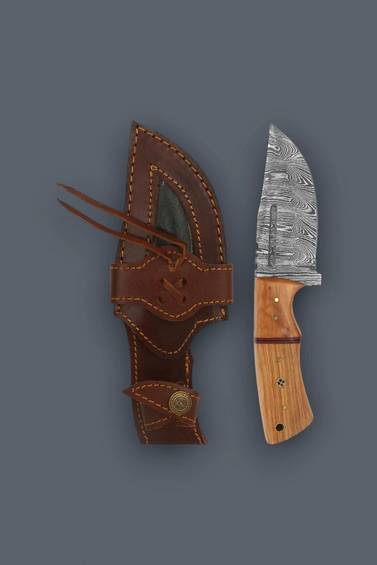 Vertical flat lay of the Damascus fixed blade hunting knife alongside its cowhide leather sheath.