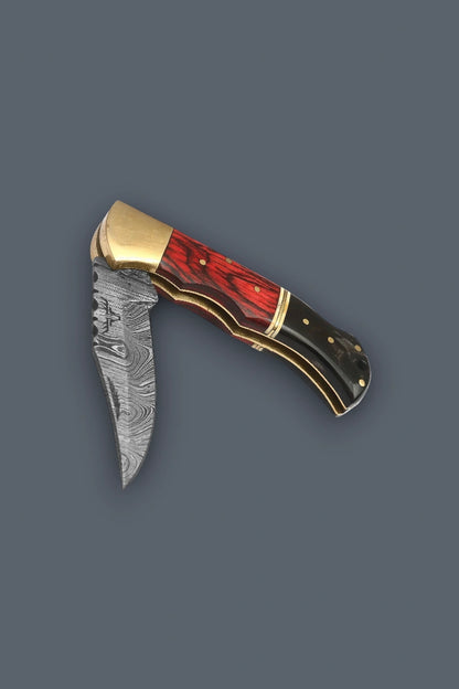 Partially folded view of the Pioneer Pocket Damascus folding knife highlighting the brass bolster and exposed brass liners.