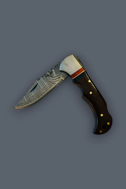 Flat lay of the partially deployed The Gentry Knife at a 90-degree angle, showcasing the blade pivot mechanism and dark wood handle.