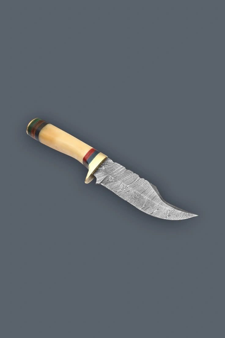 Downward diagonal flat lay displaying the reverse side of the Damascen Knives fixed blade, featuring the curved trailing point blade and symmetrical handle banding.