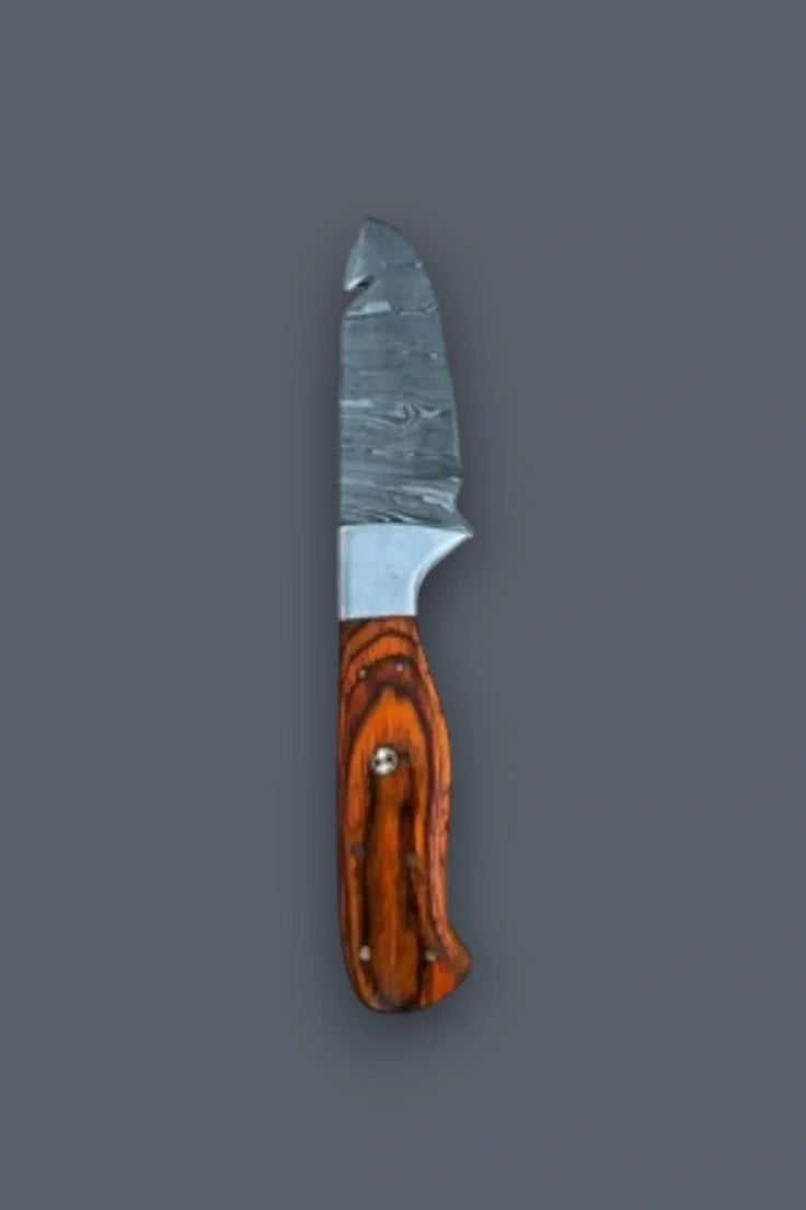Vertical flat lay displaying the reverse side of the Damascus steel fixed blade hunting knife, emphasizing the vibrant wood grain handle and spine gut hook.
