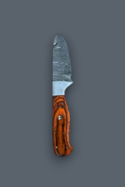 Vertical flat lay displaying the reverse side of the Damascus steel fixed blade hunting knife, emphasizing the vibrant wood grain handle and spine gut hook.