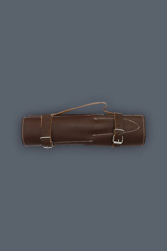 Horizontal flat lay of the rolled genuine leather case for the 5-piece Damascus kitchen knife set, featuring dual buckle straps and a carrying handle.