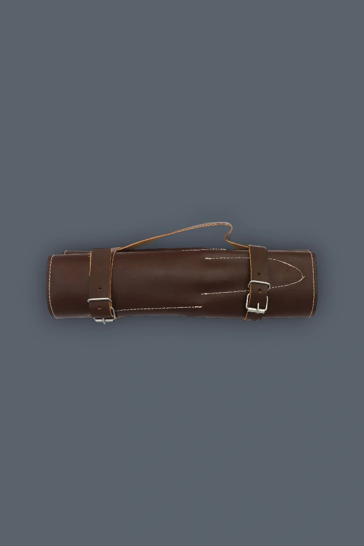 Horizontal flat lay of the rolled genuine leather case for the 5-piece Damascus kitchen knife set, featuring dual buckle straps and a carrying handle.