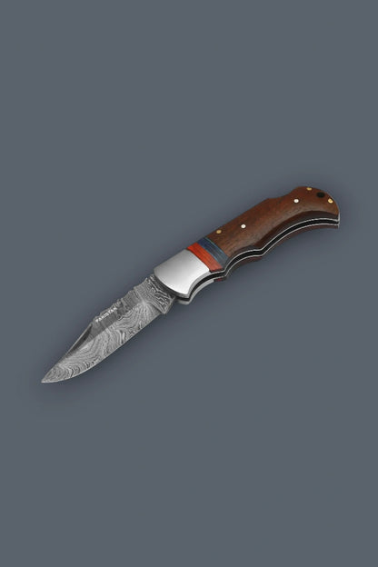 Downward diagonal flat lay of the fully open The Gentry Knife emphasizing the classic lockback profile, custom wood handle, and Damascus steel blade.