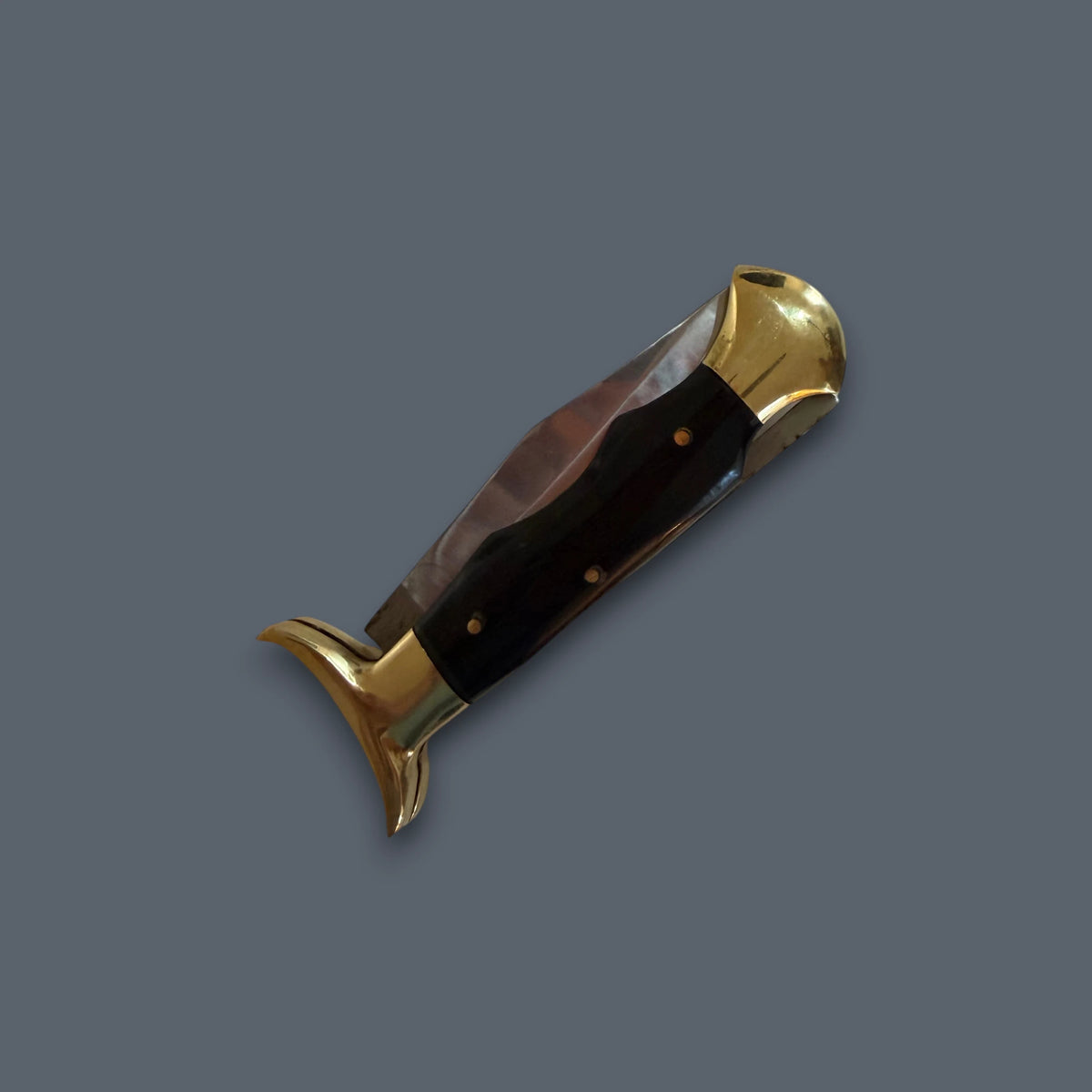 A folding pocket knife with a dark brown wooden handle and polished brass-colored metal accents, shown open against a solid dark gray background.