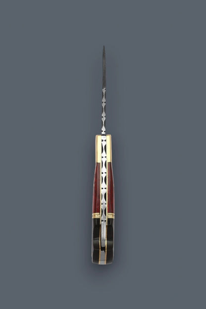 A folding pocket knife with a silver-toned metal blade and handle, featuring a reddish-brown and gold geometric inlay pattern, shown against a solid dark gray background.